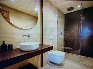 a bathroom with a sink and a toilet and a mirror at Top Appartment Cozy in Ersigen