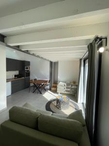 una sala de estar con un sofá y una mesa en Maison en Provence avec terrasse privée - Fibre TV, en Lambesc
