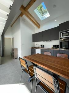 Una cocina con una gran mesa y sillas de madera. en Maison en Provence avec terrasse privée - Fibre TV, en Lambesc