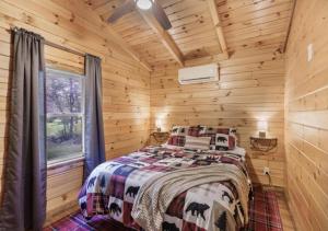 a bedroom with a bed in a log cabin at Copperhead Cabin- Hocking Hills Hot Tub Games in Logan