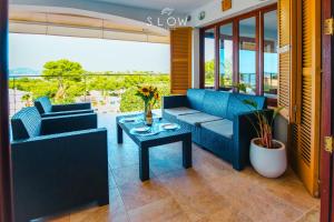 un soggiorno con due divani blu e un tavolo di Villa Monsita by Slow Villas a Santa Ponsa
