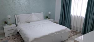 a bedroom with a white bed and a window at Casa Raluca in Bicaz Chei