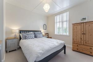 索海姆North View - Norfolk Cottage Agency的带床、梳妆台和窗户的卧室