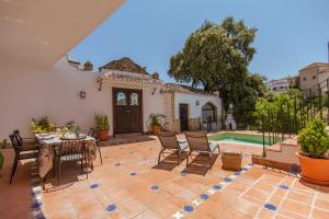 a patio with a table and chairs and a pool at The Gorge House in Ronda