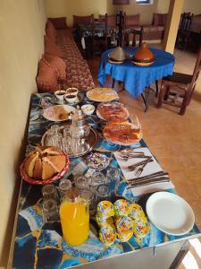 una mesa con un paño de mesa azul con comida y bebida en Sahara Sands Hotel, en Merzouga