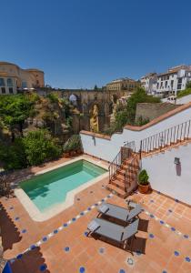 una piscina con 2 tumbonas y un edificio en The Gorge House, en Ronda
