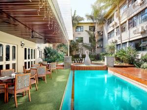 比勒陀利亚ANEW Hotel Capital Pretoria的带游泳池和桌椅的户外露台
