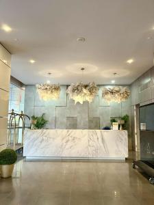 a lobby with a marble counter and chandeliers at Minimalist 1BR Condo with NETFLIX at AEON TOWERS near Abreeza Mall by Rico in Davao City +32 photos