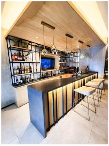 a kitchen with a bar with stools and a tv at Minimalist 1BR Condo with NETFLIX at AEON TOWERS near Abreeza Mall by Rico in Davao City