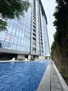a swimming pool in front of a building at Minimalist 1BR Condo with NETFLIX at AEON TOWERS near Abreeza Mall by Rico in Davao City