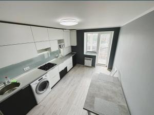 a kitchen with a sink and a washing machine at ApartPoltava 1-bedroom з великою кухнею та шикарною панорамою на АНТОНА ГРИЦАЯ,10 in Poltava +6 photos