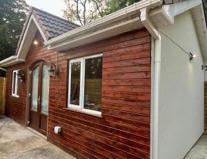 a wooden building with a door and a window at Cosy Country Cottage Near Emerald Park in Dunshaughlin