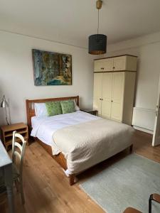 a bedroom with a bed and a table and a table and chairs at Large garden-view room, 20 min from Central London, in a stylish period property in Lee, with free parking and a friendly Jack Russell in London