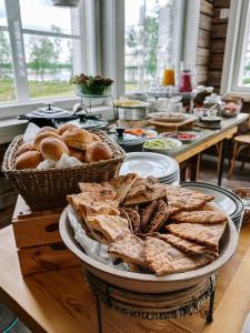 a table topped with baskets of bread and pastries at Loimu Resort in Ylläsjärvi
