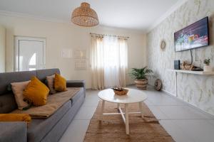 una sala de estar con un sofá y una mesa en Homebyvi, en Quarteira