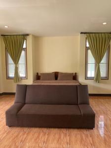 Nathon BayにあるGreen Heaven Bungalowsのベッドと2つの窓がある寝室