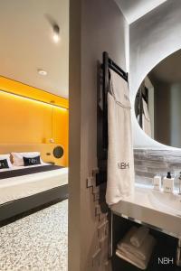 a bathroom with a sink and a bed at Nola Boutique Hotel in Nola