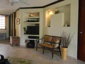sala de estar con silla y TV en Apartment Continental Beach Resort, en Río Grande