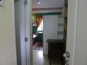 Un pasillo con una puerta abierta a una habitación con una mesa. en Amabel's Condo Unit FC, en Baguio 1 foto más