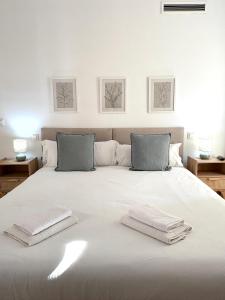 a white bed with two towels on top of it at The Zentral Suites & Apartments in Seville