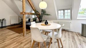 クレーフェルトにあるDenkmal-Apartment zentral in Krefeld mit hohen Deckenの白いテーブルと椅子のあるダイニングルーム