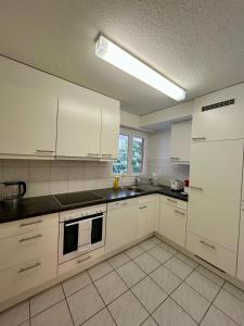 a large kitchen with white cabinets and a window at Chic Comfort in a Prime Zurich Location in Zürich