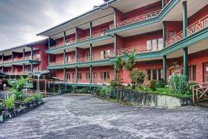 a large red building with a driveway in front of it at Hotel O 90596 Hotel Griya Astoeti in Bogor