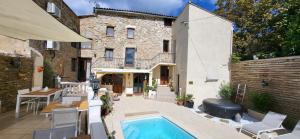 a backyard with a swimming pool and a building at La maison millesime in La Caunette