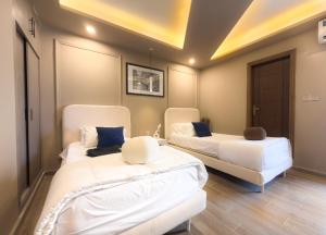 two white beds in a room with a ceiling at The Marrakesh Suites - Skyline ApartHotel In Bahria Town in Rawalpindi