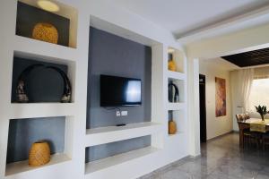 a living room with a flat screen tv on a wall at Bon Bini Residence in Kampala