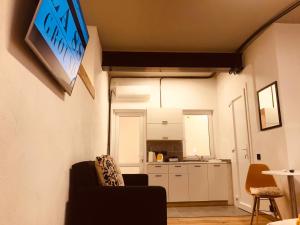 a living room with a couch and a kitchen at Budget Rooms by LA88 in St. Paul's Bay