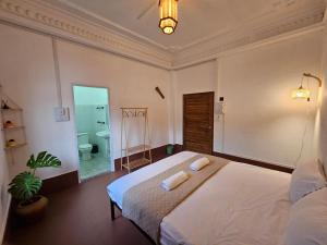 a bedroom with a bed with two towels on it at Monkey Guesthouse - Savannakhet in Savannakhet