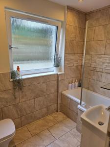 bagno con vasca, servizi igienici e finestra di Balnakeil house  Altre 12 foto