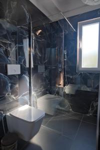 a bathroom with a toilet and a window at 3D Hotel in Tirana