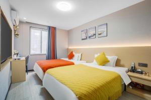 a hotel room with two beds and a television at L-Magic Design hotel in Guangzhou