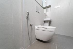 a white toilet in a bathroom with a shower at Mathi Residency in Chennai