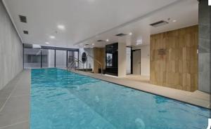 a large swimming pool with blue water in a building at Melborne Collins Home in Melbourne
