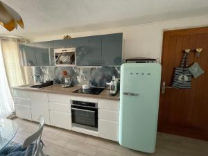a kitchen with a white refrigerator and a table at Duplex plage des chalets Gruissan plage in Gruissan