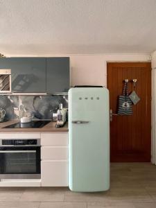 a kitchen with an old refrigerator in front of a stove at Duplex plage des chalets Gruissan plage in Gruissan