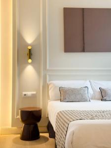 a hotel room with two beds and a light on the wall at Ópera Stays by Charming in Madrid