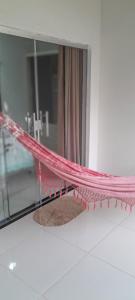 a pink hammock in front of a mirror at Villas dos Pássaros in Porto Seguro