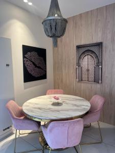 a dining room with a table and pink chairs at Villamelina in Puteaux