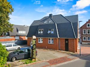 a red brick house with a black roof at 10 Rooms City Apartments in Emden