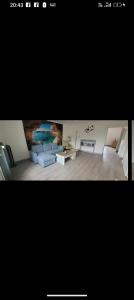 a living room with a couch and a table at Maison 2 chambres doubles cour et jardin 