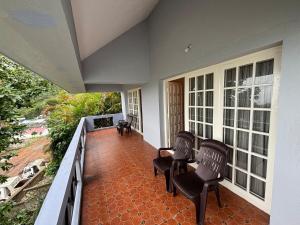 a porch with two chairs and two windows at Scenic Family Retreat in Kodai! Kodai Sierra in Kodaikānāl