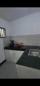 a kitchen with a sink and a black counter top at Stay at Amazing Grace, whole unit- VCDU subdivision , Mabini Plains in Mabini +6 photos