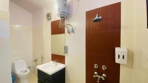 a small bathroom with a toilet and a sink at Athiti Kunj Eco Adventure Retreat in Mukteswar