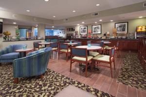 a restaurant with tables and chairs and a bar at Baymont by Wyndham Thornton in Thornton