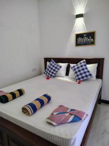 a bed with blue and white pillows on it at Sunee'S Home Stay in Ahangama