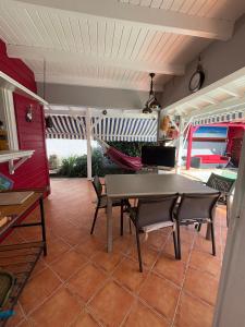 a patio with a table and chairs and a hammock at Villa malaurelia in Saint-François